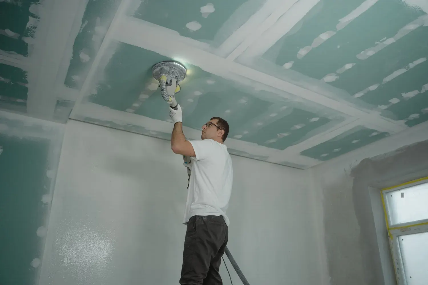 Drywall contractor work in Marietta, GA: sanding a drywall ceiling smooth
