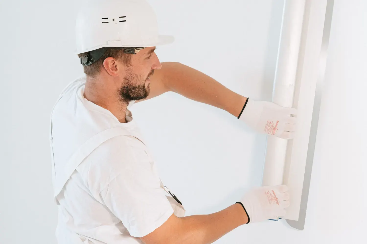 Drywall repair in Marietta, GA: worker smoothing joint compound across a wall