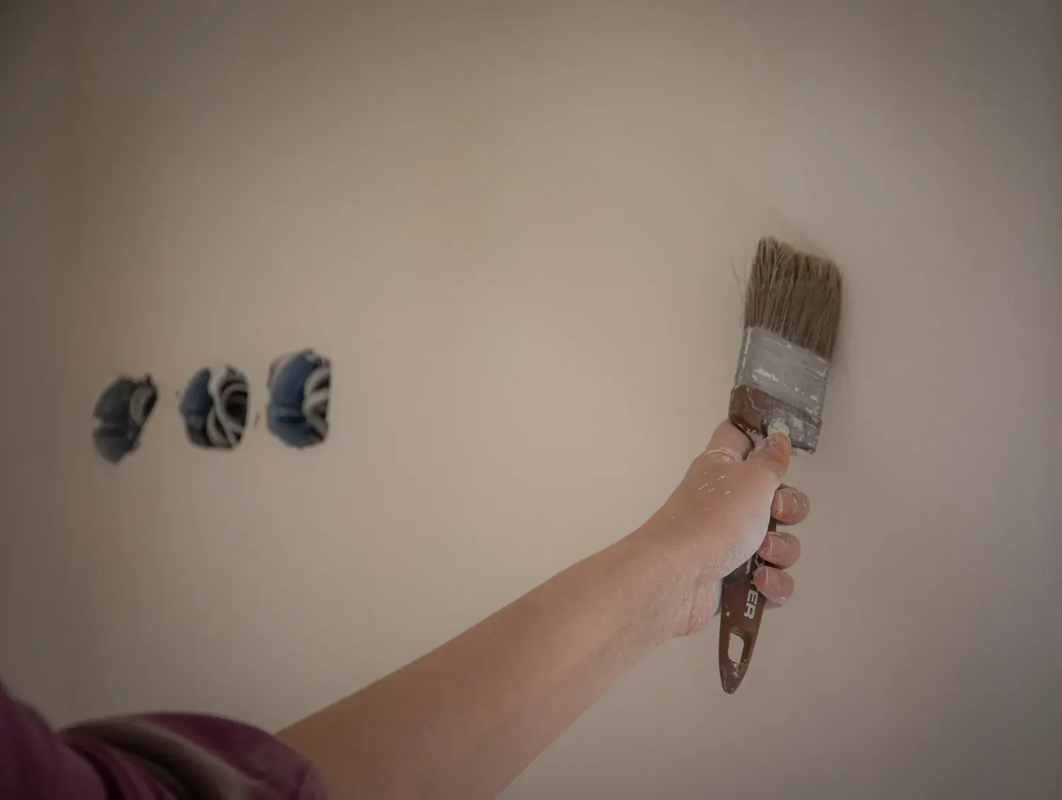 House painting in Marietta, GA: brush loaded with fresh paint on a prepared wall